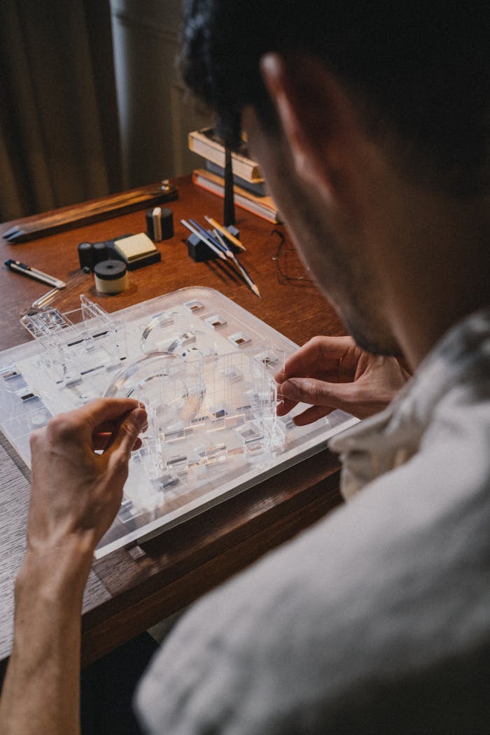 Architect at work crafting a detailed architectural model indoors.